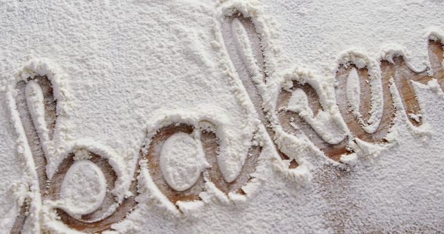 Handwritten baking word is traced on a surface dusted with flour, with copy space. It suggests a homey, kitchen setting where baking activities are about to commence or have just concluded.