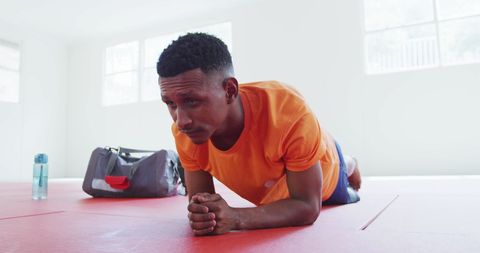 Biracial Teen Practicing Plank Exercise in Gym Environment