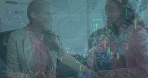 Businesswomen discussing strategies amidst financial data overlay