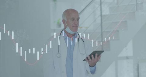 Senior Doctor Analyzing Data with Tablet in Hospital Environment