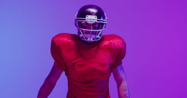 Image of caucasian american football player in helmet with ball over neon purple background. American football, sports and competition concept.