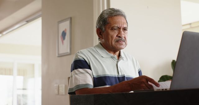 Senior Man Using Laptop at Home Office with Focused Expression - Download Free Stock Images Pikwizard.com