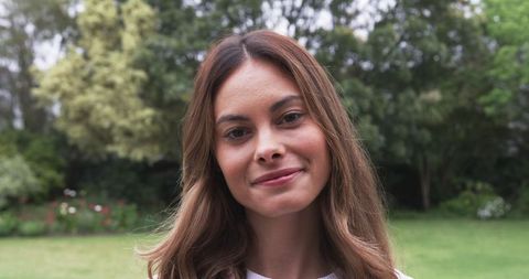 Woman Smiling Peacefully in Lush Backyard Garden
