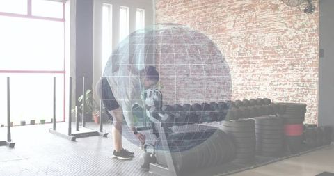 Woman picking up kettlebell in gym with globe overlay representing global fitness trend