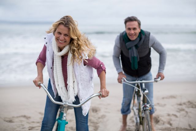 Portrait of mature couple riding bicycles on the beach 