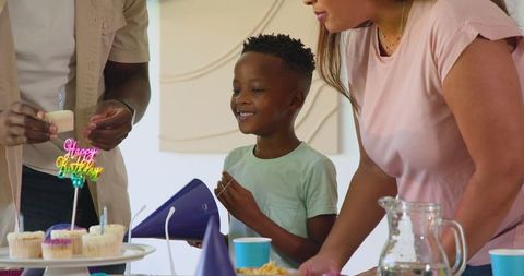 Family Celebrating Birthday with Cupcakes and Party Decorations