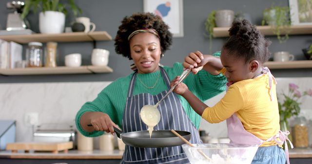 Mother and daughter making pancakes in modern kitchen - Download Free Stock Images Pikwizard.com