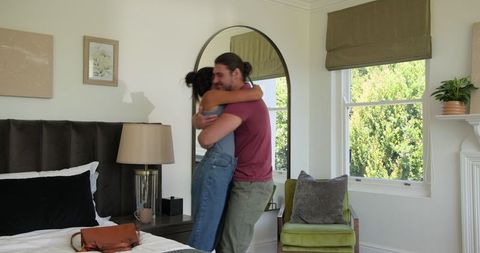 Happy Couple Embracing in Cozy Hotel Room Setting
