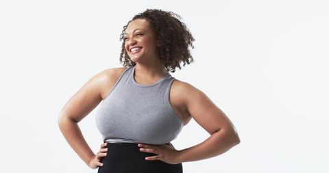 Confident plus-size woman smiling with hands on hips