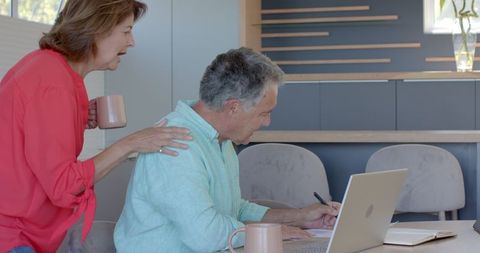 Senior Couple Using Laptop for Online Activities at Home