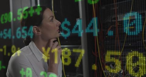 Data Engineer Examining Servers with Overlayed Financial Data