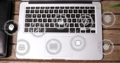 Silver Laptop on Wooden Desk Displaying Floating HUD Icons for Productivity and E-Learning