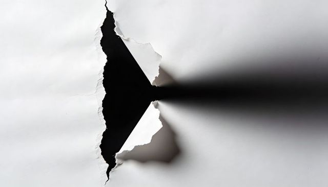 Torn White Paper Revealing Jagged Triangle Void with Dramatic Shadow and Curled Edges