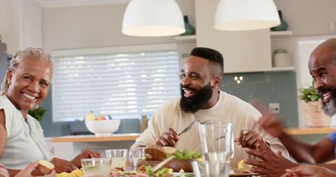 Joyful African American Family Sharing Meal at Dining Table