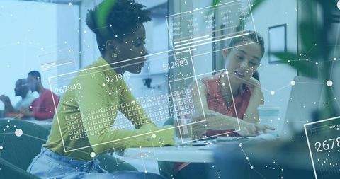 Female Professionals Collaborating in Open Office with Digital Overlay