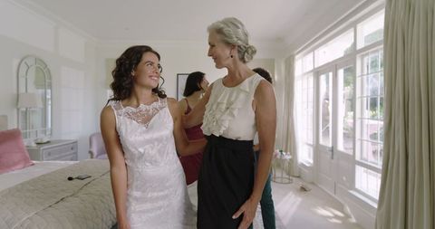 Bride Expressing Joy with mother figure in Sunlit Room