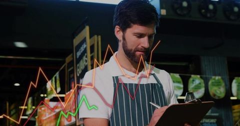 Bearded man checking retail inventory with clipboard and analytics overlay in supermarket