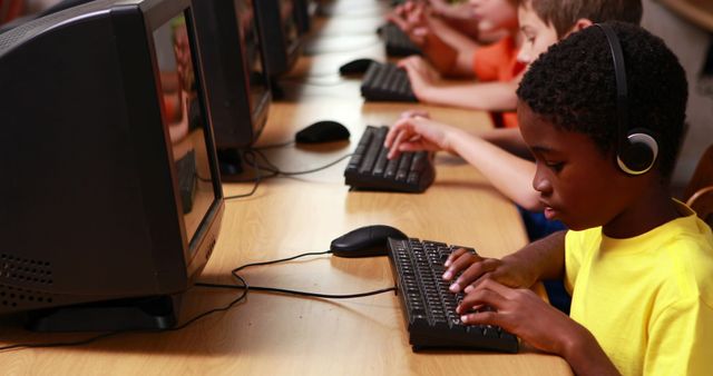Row of pupils working in computer class in elementary school