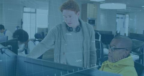 Developers Collaborating Over Computer Screens in Open Plan Office