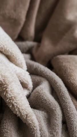 Shifting camera revealing plush fleece throw folds close-up vertical video texture