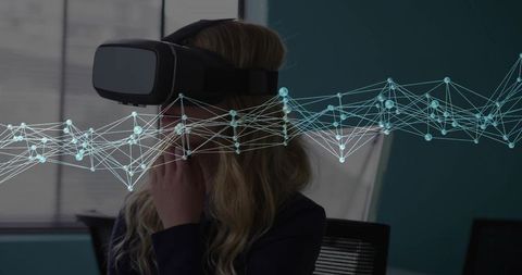 Woman using vr headset with digital network overlay in office