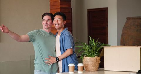 Diverse Gay Couple Joyfully Celebrating with Moving Boxes