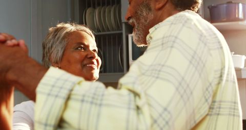 Senior Couple Joyfully Dancing in Sunlit Kitchen
