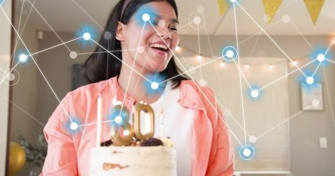 Smiling woman celebrating 30th birthday with cake, gold topper, party decor and network overlay