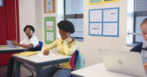 Students Engaged in Computation and Writing at Classroom Desks
