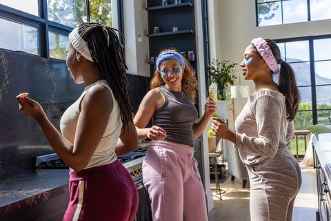 African american women enjoying self-care party in sunlit modern kitchen