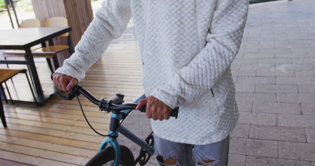 Person Dressed in White Sweater Holding Bike Handlebars - Download Free Stock Images Pikwizard.com