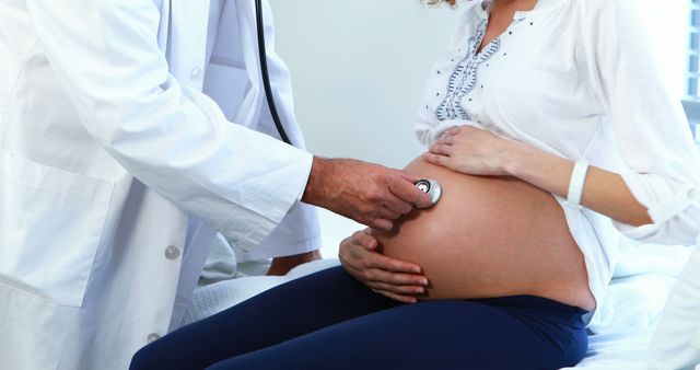 A doctor closely examining a pregnant woman's belly with a stethoscope. Suitable for illustrating topics related to prenatal care, pregnancy health, maternity services, expectant motherhood, and medical checkups during pregnancy. Useful for healthcare websites, pregnancy blogs, medical guides, and educational materials on prenatal care.