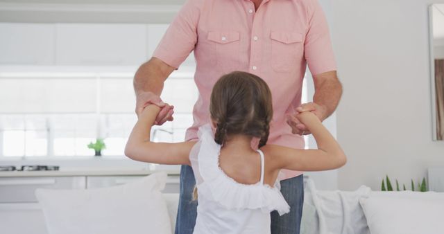 Happy caucasian grandfather and granddaughter holding hands and jumping on sofa - Download Free Stock Photos Pikwizard.com