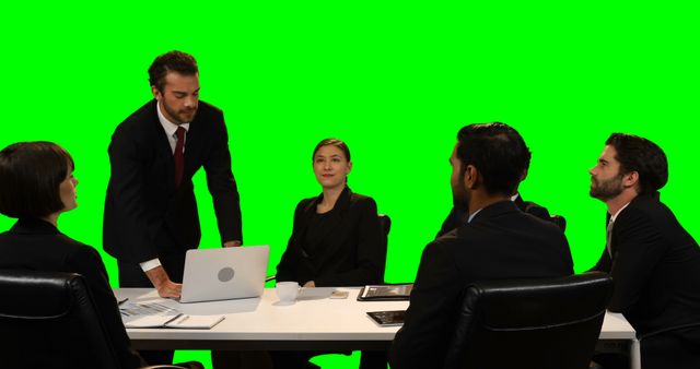 Group of business professionals having a meeting at conference table. Diverse team dressed in formal attire engaging in discussion and presentation. Green screen background allows for easy customization and visual effects. Ideal for business, corporate, and teamwork-related content, promotional materials, or presentations.