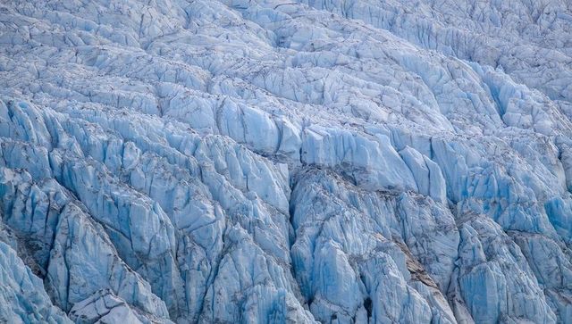 Glacier revealing deep crevasses, jagged seracs, ridges and moraine streaks