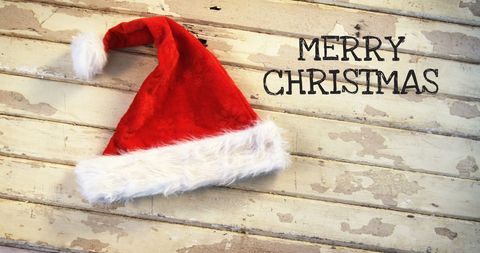 Santa Hat with Merry Christmas Text on Rustic Wooden Background