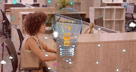 Professional Woman Typing with Holographic Innovation Symbol in Office