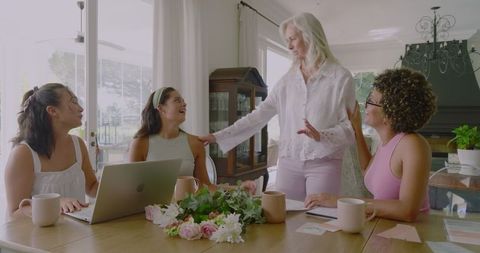 Elderly Woman with Young Adults Collaborating on Event Planning