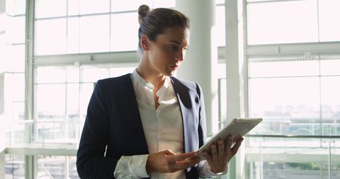 Focused Businesswoman Analyzing Data on Tablet in Modern Office - Download Free Stock Images Pikwizard.com