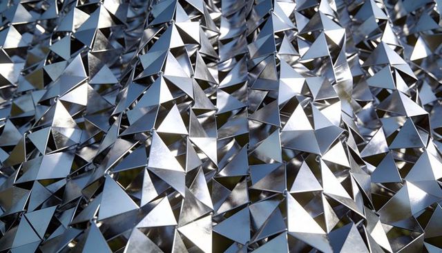 Reflective Tetrahedral Metal Panels Creating Diagonal Geometric Tessellation for Facade