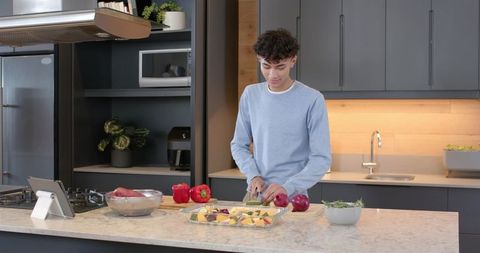 Young Man Preparing Vegan Meal in Modern Kitchen