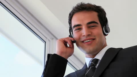 Confident Businessman with Headset Laughing in Office