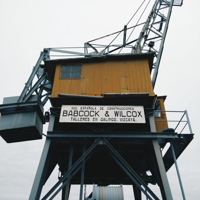 Historic industrial crane at Babcock & Wilcox facility in Vizcaya, Spain. Ideal for use in industry-themed publications, engineering technology articles, and historic architecture studies. Perfect for emphasizing themes of construction, machinery, and historical industrial technology.
