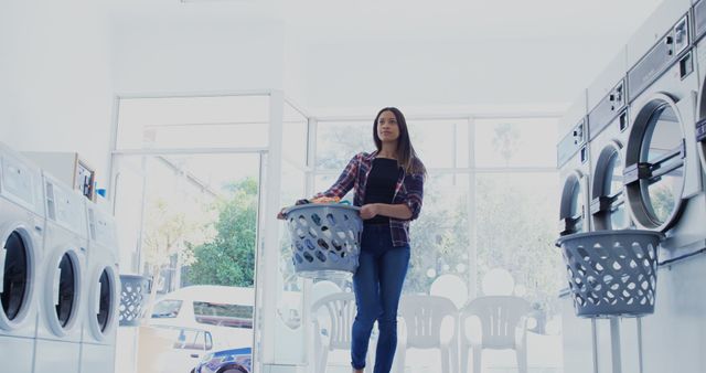 Young Woman Carrying Laundry Basket in Modern Laundromat - Download Free Stock Images Pikwizard.com