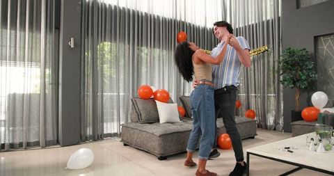 Cheerful Couple Dancing in Living Room at Birthday Celebration
