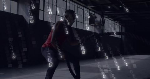 Athlete swinging battle ropes with digital binary overlay in industrial gym workout