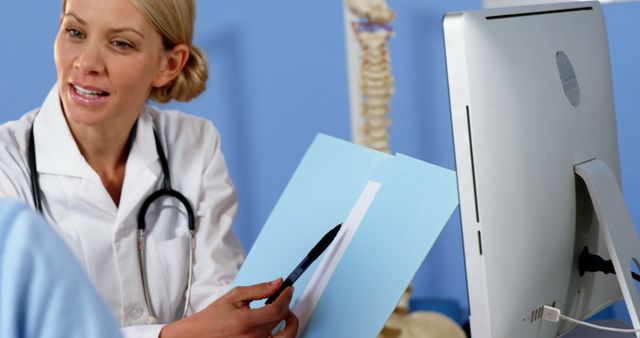 A Caucasian female doctor reviews medical images at her computer, with copy space. Her focused expression and professional attire underscore the importance of accurate diagnosis in healthcare.