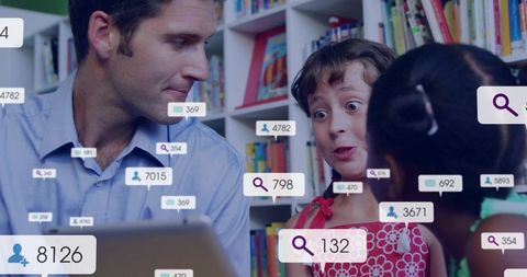 Teacher guiding curious students with tablet and interactive digital ui in colorful library