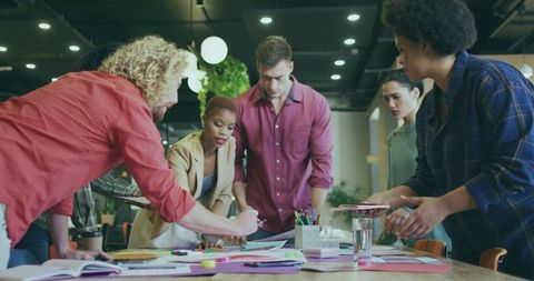 Creative team brainstorming over sketches in modern office