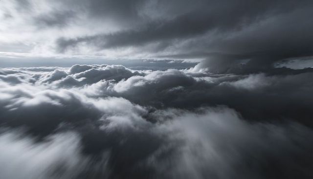 Swirling storm cloudscape revealing dramatic light shafts over turbulent cumulonimbus